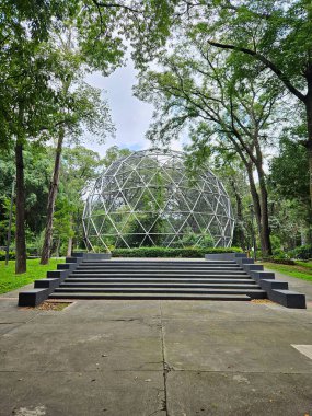 Agua Azul Park 'ın jeodezik kubbesi Guadalajara' nın dikey görüntüsü. Modern küresel mimari, yemyeşil ağaçlar, karanlık merdivenler, kentsel doğa karışımı.