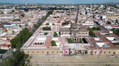 Diagonal drone video of Cabanas Cultural Institute, Guadalajara, Mexico. Historic neoclassical building, courtyards, urban landscape.