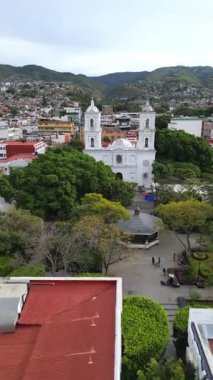 Hava dikey çekimi Chilpancingo Katedrali 'ne doğru ilerliyor, plaza ve ağaç tepe örtüsünü geçiyor.