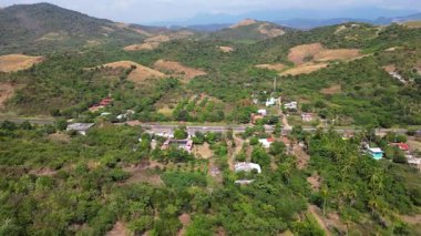 İnsansız hava aracı görüntüleri küçük bir çiftlik, köy, otoyol ve Meksika 'nın Guerrero kentindeki yeşil tepelerle çevrili mavi gökyüzü olduğunu gösteriyor.