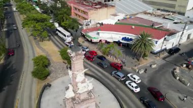 Guadalajara, Meksika - 8 Kasım 2025: Guadalajara hava manzaralı, Bağımsızlık Anıtı. Şehir kavşağında şehir trafiği ve binaları olan bir melek heykeli.
