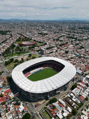 Guadalajara, Meksika 'daki Estadio Jalisco' nun dikey hava aracı görüntüsü. Stadyum, uzak dağları olan yoğun şehir manzarasında göze çarpıyor..