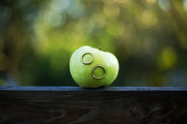 Anneaux de mariage dans une pomme verte — Photo