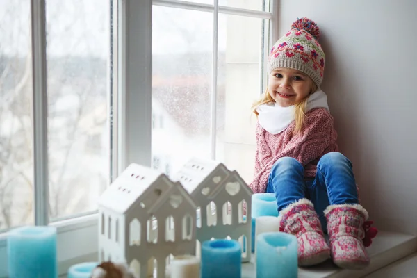 Girl sitting on a window sill — Stock Photo, Image