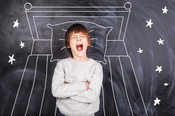 Çocuk esner ve boyalı yatak arka plan üzerinde