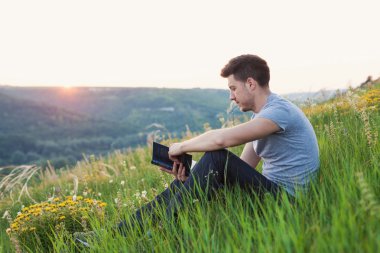 adam tepeye ve bir kitap okuma oturur