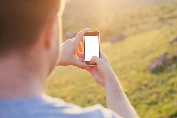 El hombre sostiene el teléfono en las manos con la pantalla blanca — Foto de Stock