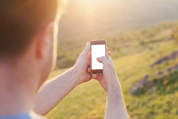 Hombre mantenga el teléfono con la pantalla blanca — Foto de Stock