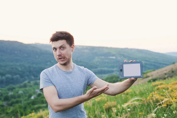 Homme debout sur la colline tenir un eBook et souriant étrange — Photo