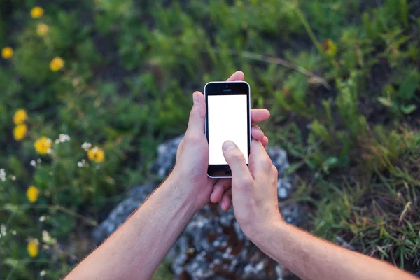 Las manos de los hombres sostienen el teléfono con la pantalla blanca y el tacto disipar — Foto de Stock