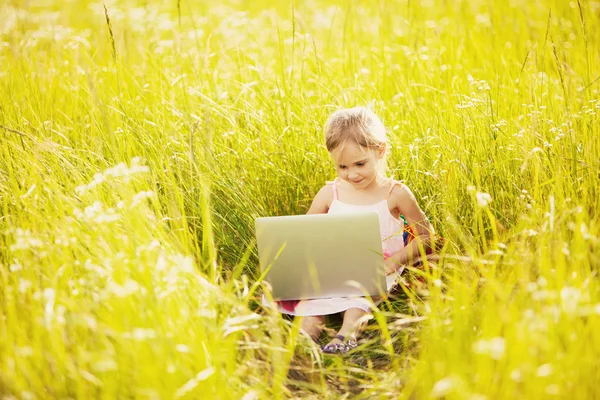 Linda niña con portátil en la naturaleza — Foto de Stock