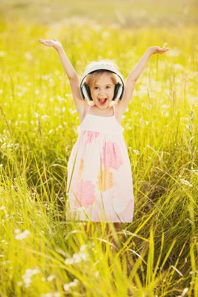Щаслива маленька дівчинка з навушниками — стокове фото