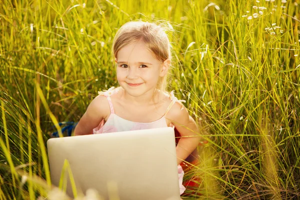 Sonríe niña con el ordenador portátil — Foto de Stock