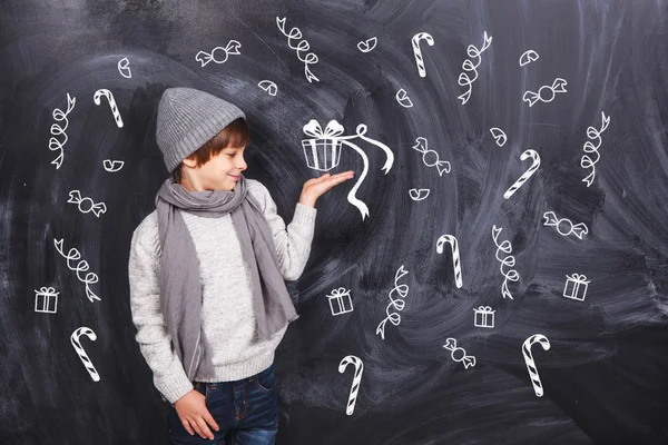 Boy dreams of gifts with candy — Stock Photo, Image