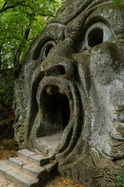 Canavar Sacro Bosco 'nun Bomarzo Parkı, Viterbo. Mitolojik hayvanları, tanrıları ve canavarları tasvir eden sayısız bazalt heykellerle süslenmiş doğal bir park. Orcus Ağzı 'nın ayrıntıları.