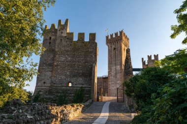 Valeggio sul Mincio 'nun ortaçağ Scaligero şatosuna giriş, tuğla kalıntıları, kule ve rendelenmiş duvarların detayları, mavi gökyüzü ile bir yaz günü. Verona, İtalya.