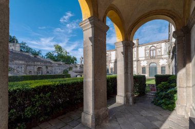 Monselice Santuario delle 7 Chiese, San Giorgio kilisesinin mavi gökyüzü ve bulutlarla dolu bir yaz gününde Villa Duodo meydanındaki kemerlerinin manzarası, Veneto, İtalya.