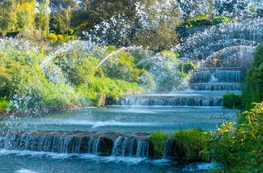 Roma 'nın merkezindeki Eur bölgesindeki göletin şelaleleri. Mavi gökyüzü olan bir bahar gününde suyun güzel yansımaları. Roma Eur, İtalya.