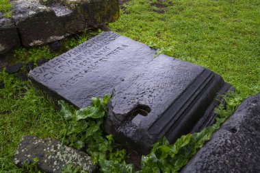 Valerius, Appia Antica 'nın mezarından güzel bir yazı. Bir sonbahar gününde, gök gürültülü bir fırtınayla. Levha ıslak ve yeşil çimenlerin ve bitkilerin ortasında duruyor. Roma Regina Viarum İtalya.
