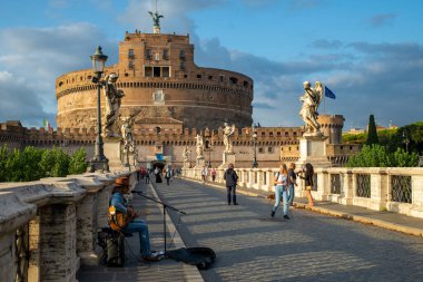 Castel Sant 'Angelo, Mausoleo di Adriano, Vatikan, Tiber üzerinde Ponte degli Angeli' den bir müzisyenle sonbahar günü, gök gürültülü fırtınadan sonra, Vatikan, Roma, İtalya.