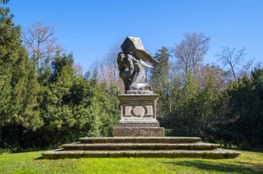 Villa Barbarigo Galzigliano Terme bahçesinde ağır bir yük taşıyan zaman heykelinin ayrıntıları. O, sol elinde bir kum saati tutuyor. Valsanzibio Padua, İtalya, Veneto.