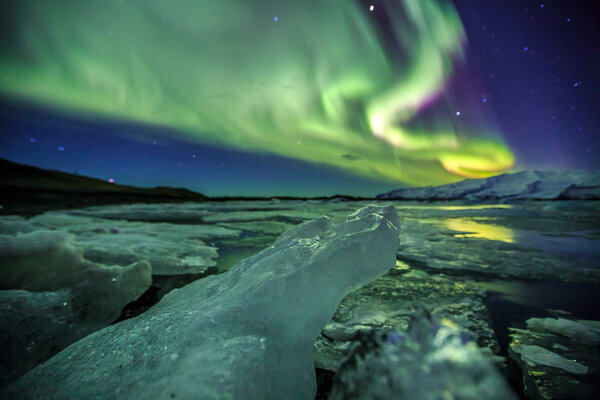 Auroral over the glacier lagoon Jokulsarlon in Iceland.