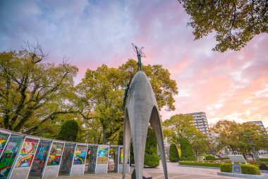 HIROSHIMA, JAPONYA - 24 Mart 2019: Japonya 'daki Hiroşima Barış Anıt Parkı' nda katlanmış kağıt vinç taşıyan bir kızın heykeli ile Çocuk Barış Anıtı.