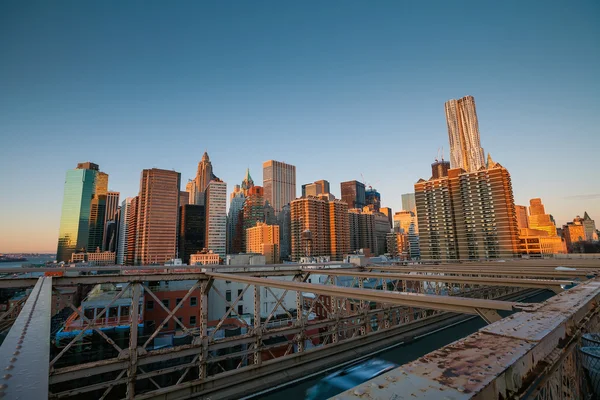 Lower Manhattan via Brooklyn Bridge bij zonsondergang, New York City — Stockfoto
