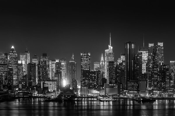 New York City with skyscrapers illuminated over Hudson River panorama in black and white