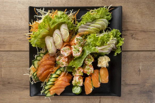 Mischung Aus Sushi Und Niguiris Auf Schwarzem Teller Auf Holztisch — Stockfoto