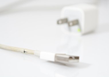 Tatlı beyaz arka plan üzerinde kırık şarj kablosu