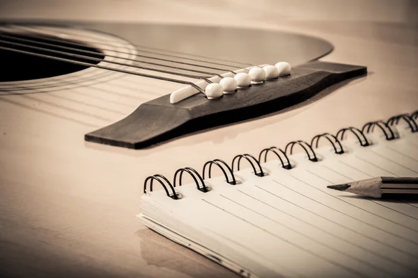 Notatnik i ołówek na tle gitara — Zdjęcie stockowe