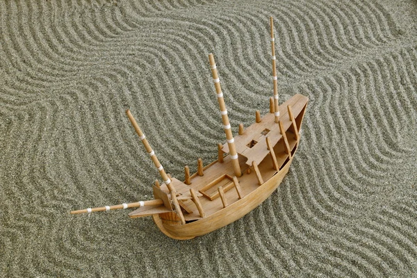 Model ship on the waves drawn on the sand — Stock Photo, Image