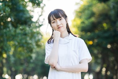 Beyaz önlüklü Asyalı genç bir kadın stresli