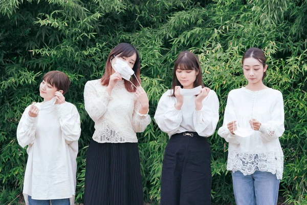 白いシャツとマスクを着た4人の若い日本人女性 — ストック写真