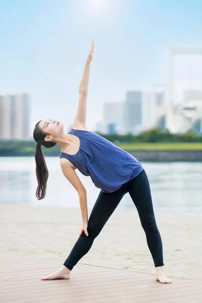 Şehirdeki Plajda Yoga Yapan Asyalı Genç Bir Kadın — Stok fotoğraf