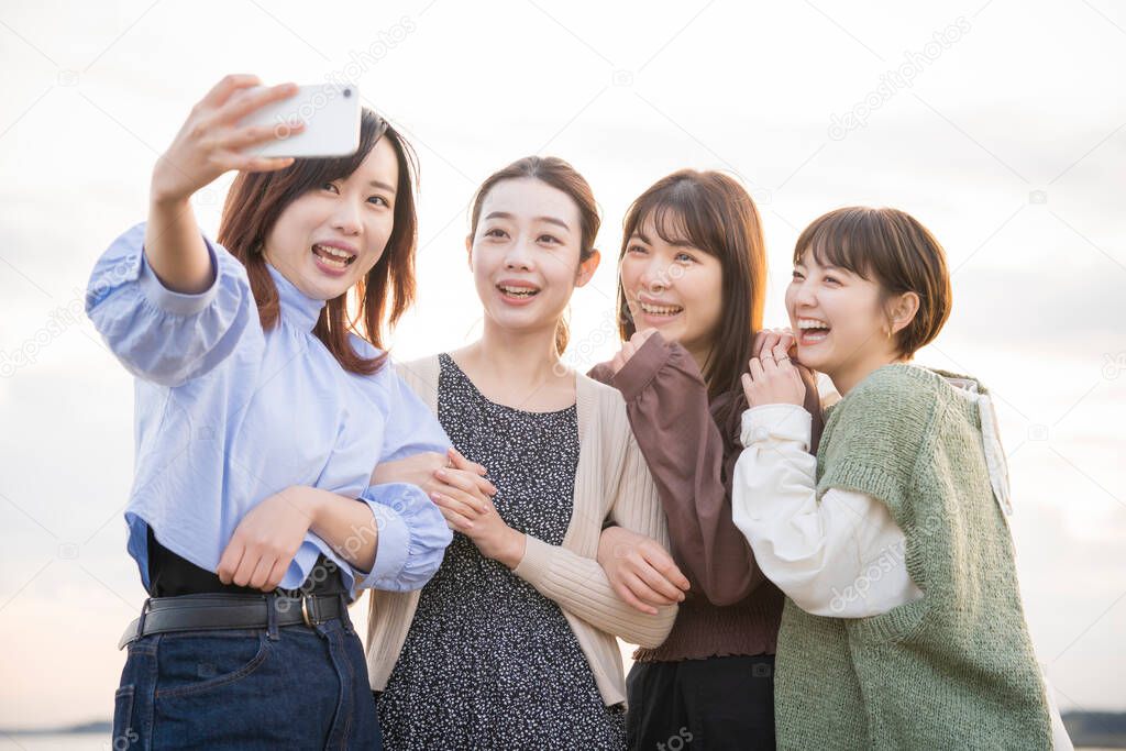 4 young women taking a commemorative photo with a smartphone