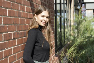 Güzel bir günde dışarıda poz veren bir kadının portresi.