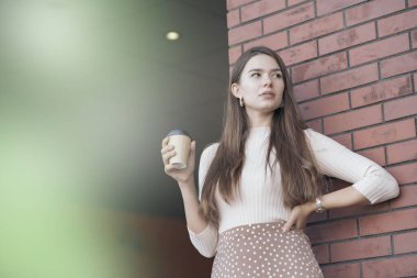 Elinde kahve fincanıyla rahatlayan genç bir kadın.