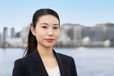 Asyalı genç iş kadını ve Tokyo şehri manzarası güzel bir günde