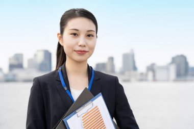 Asyalı genç iş kadını ve Tokyo şehri manzarası güzel bir günde