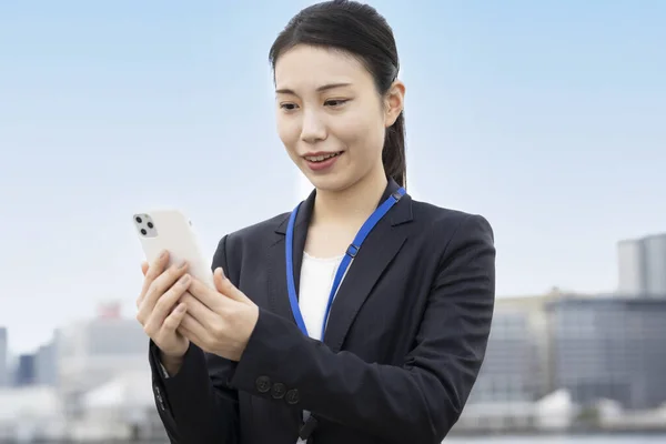 Asyalı Genç Kadını Gülümseyerek Akıllı Telefon Kullanıyor — Stok fotoğraf