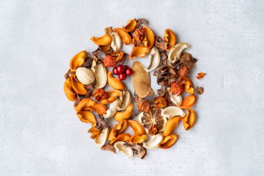 Kurumuş çiçekler ve kuru bitki ekranın ortasına serilmiş.