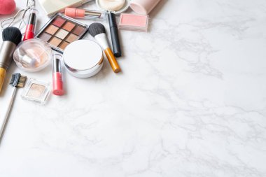 Mermer bir tabağa yerleştirilmiş makyaj malzemelerinin kuş bakışı görüntüsü