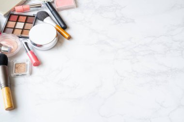 Mermer bir tabağa yerleştirilmiş makyaj malzemelerinin kuş bakışı görüntüsü