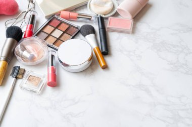 Mermer bir tabağa yerleştirilmiş makyaj malzemelerinin kuş bakışı görüntüsü