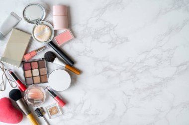 Mermer bir tabağa yerleştirilmiş makyaj malzemelerinin kuş bakışı görüntüsü