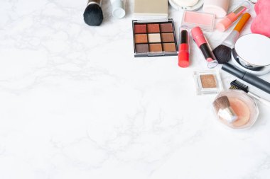 Mermer bir tabağa yerleştirilmiş makyaj malzemelerinin kuş bakışı görüntüsü