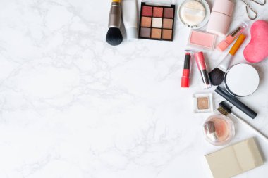 Mermer bir tabağa yerleştirilmiş makyaj malzemelerinin kuş bakışı görüntüsü