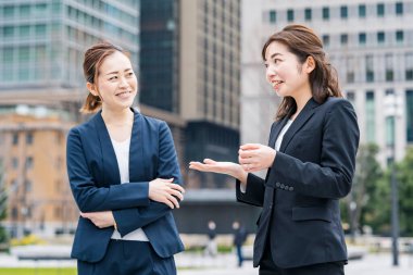 İş ekibi dışarıda rahat bir atmosferde sohbet ediyor.